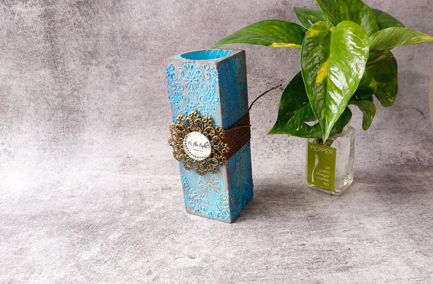 Intricate blue candle stand featuring 'Be the light' message