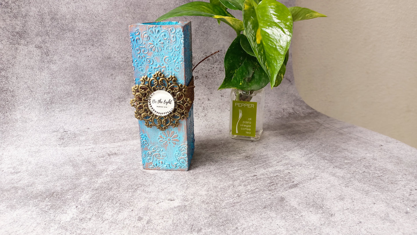 Elegant blue candle stand with 'Be the light' scripture