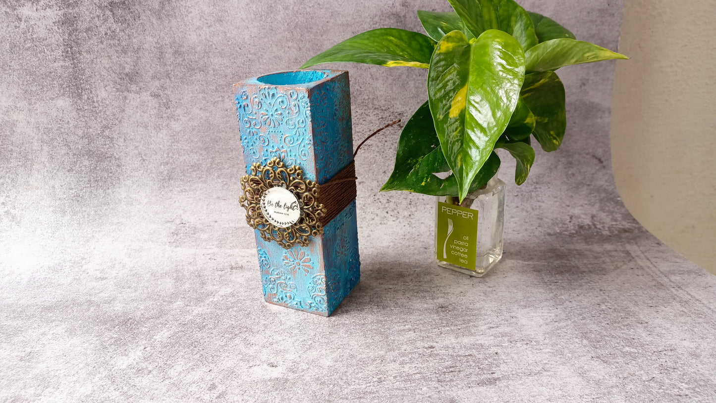 Blue ornate candle stand with 'Be the light' inscription