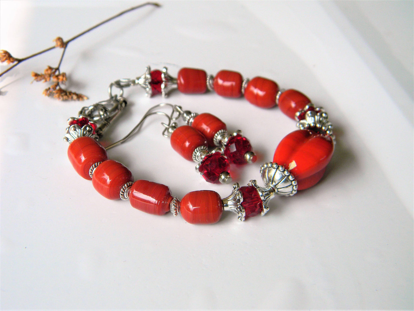 Handmade red glass bead bracelet and earrings with floral decor