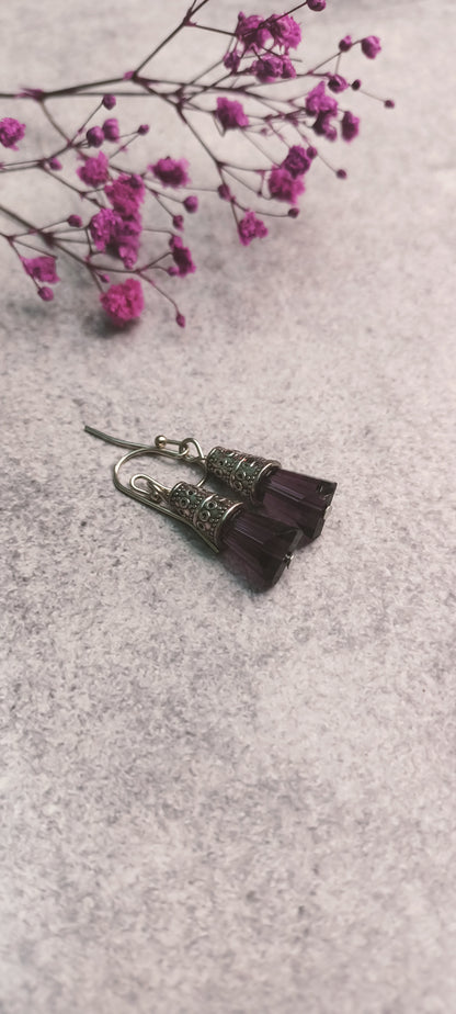 Purple glass bead earrings with intricate metal design