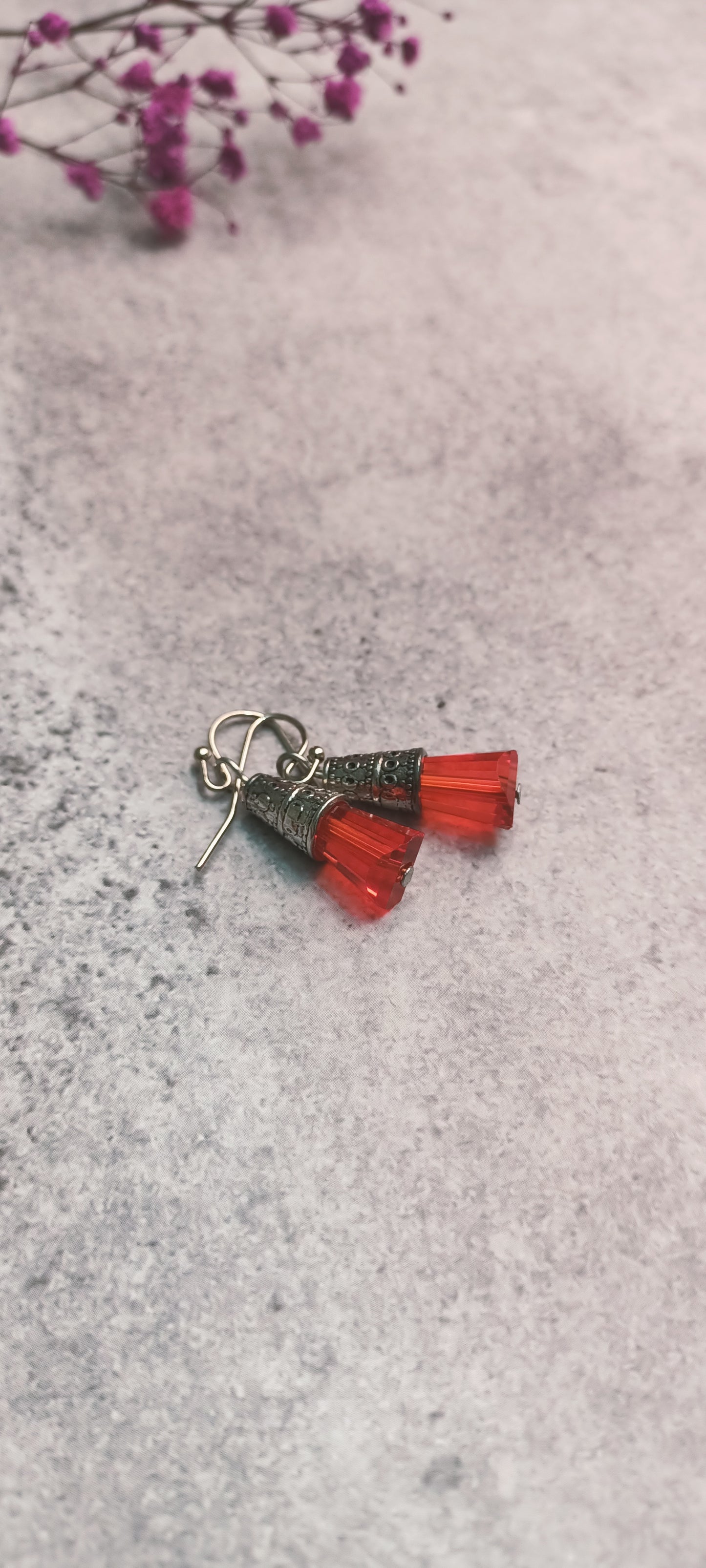 Red glass bead earrings featuring ornate metal design