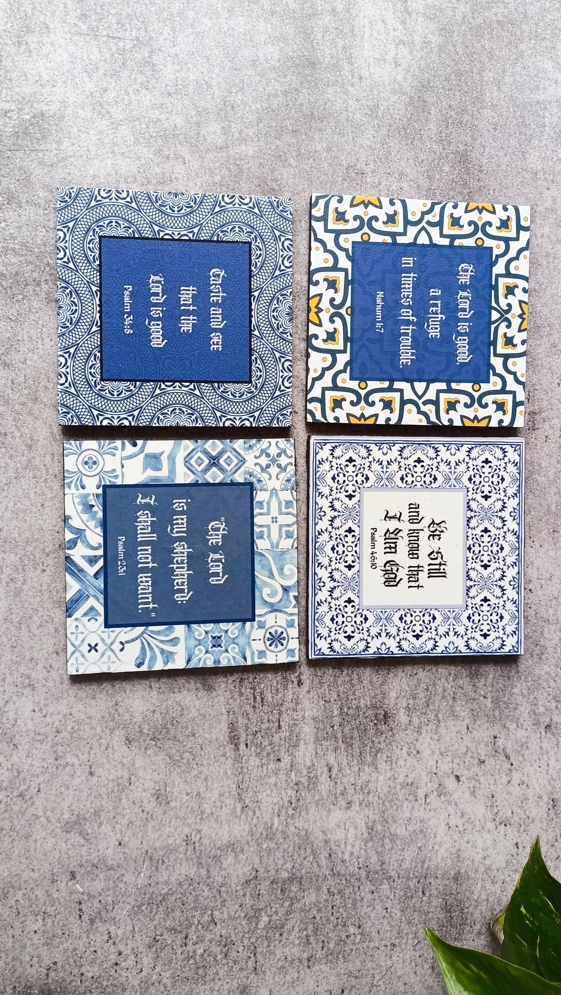 Set of four Moroccan-style scripture coasters with intricate blue and white patterns, featuring inspiring Bible verses on wood with foam backing.