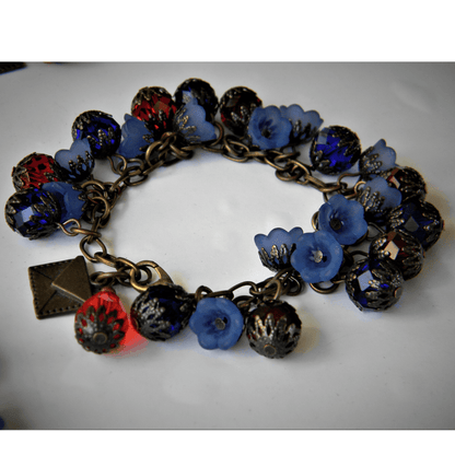 Efflorescence bracelet featuring blue flowers and red beads