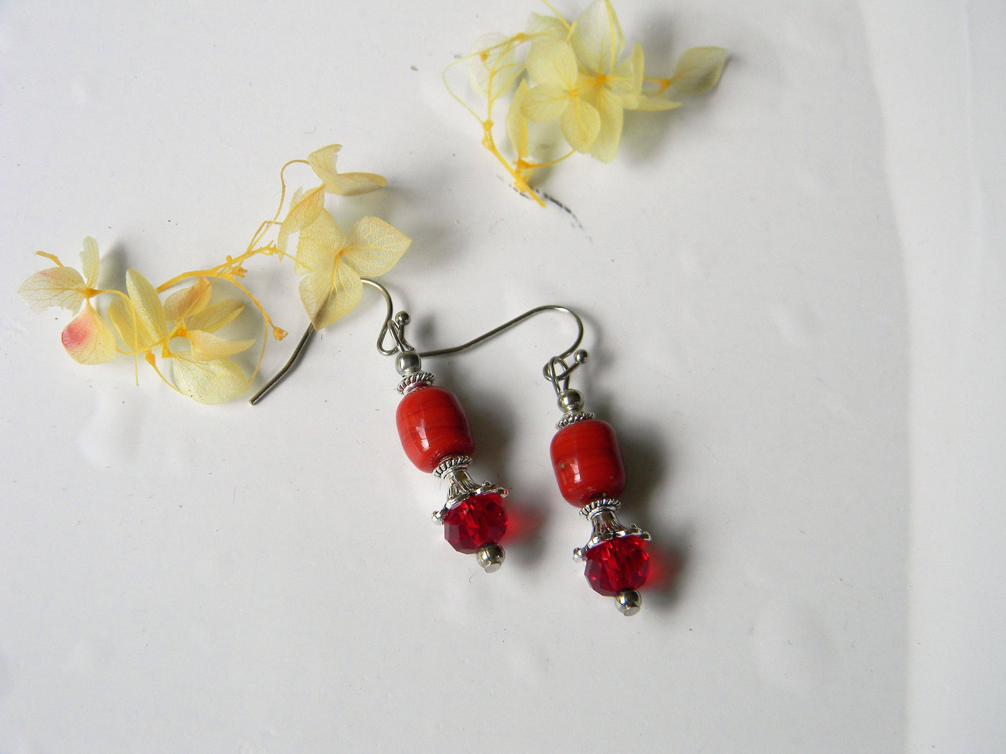 Red glass bead earrings with silver accents and floral decor